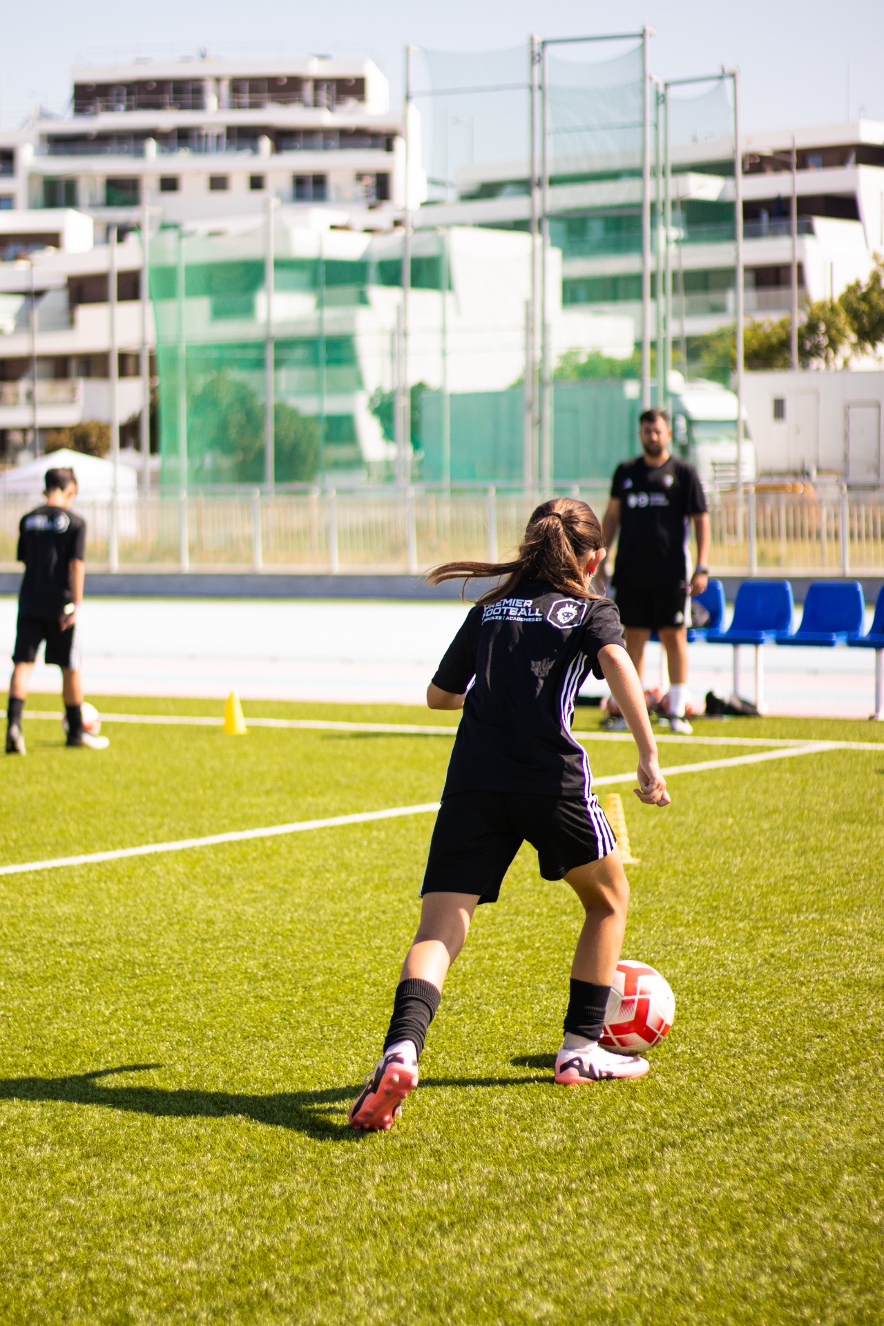 A young player practising with the ball during a Premier Football training session.