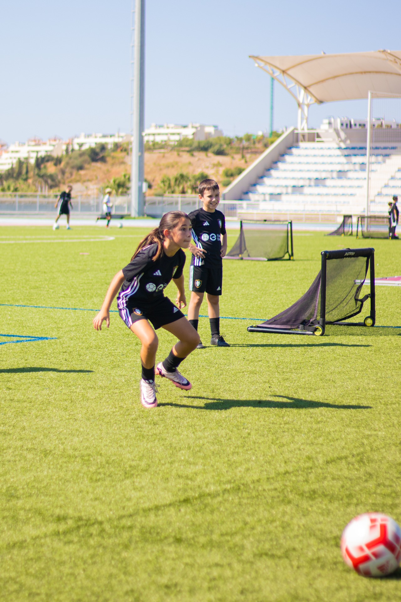 Young players taking part in a Premier Football training session on an outdoor pitch.